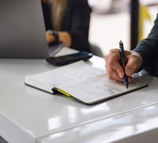 mehe käsi kirjutab märkmikusse plaani