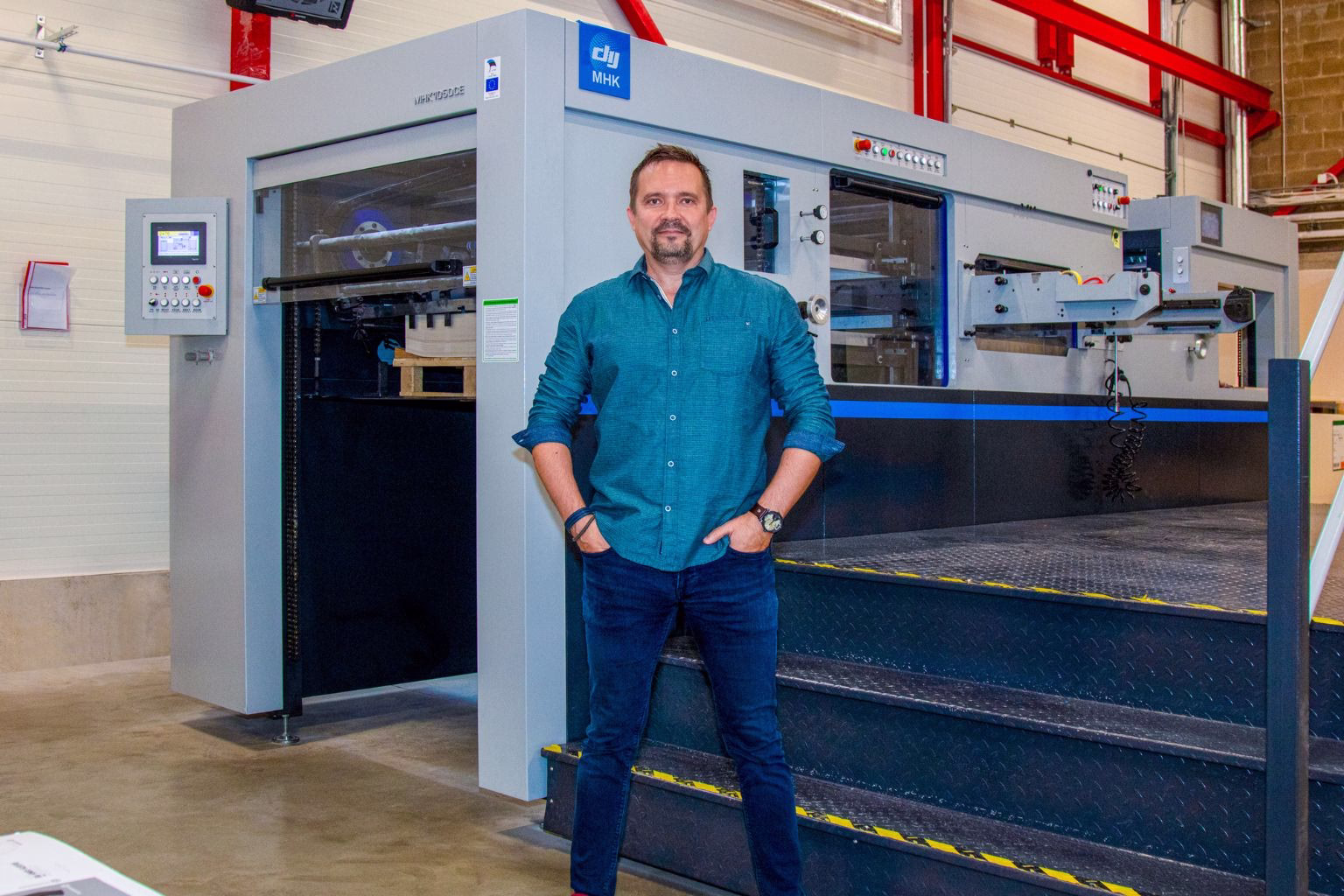 xr:d:DAFtGfb3lwg:2,j:2792633198869168894,t:23083109 trükiettevõtte tegevjuht stantsimasina juures seismaas