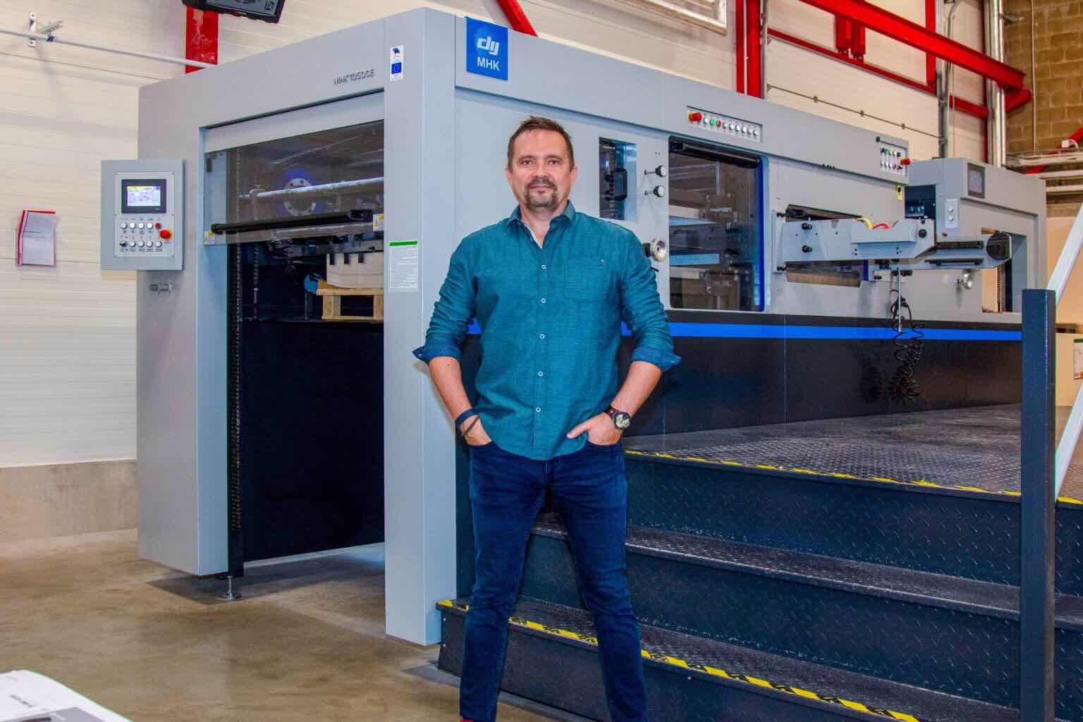 Untitled design - 5 trükiettevõtte tegevjuht stantsimasina juures seismaas